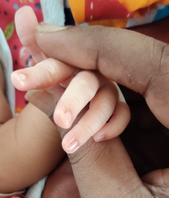 Tiny baby fingers holding a hand